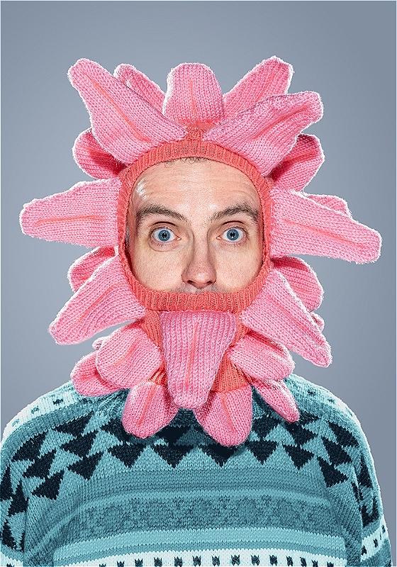 A man wears a knitted balaclava of tongues