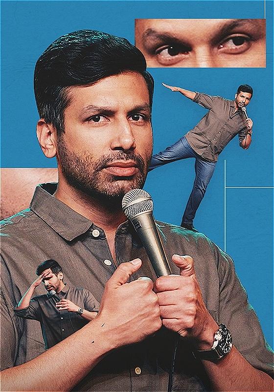 Kanan Gill, a brown Indian man with short black hair and beard and wearing a dark grey shirt and blue jeans, is holding a microphone and looking directly at the camera. On his shoulder is a smaller version of himself standing on one leg and arms out. Behind him are inserts of his eyes and ear on top of a blue background.