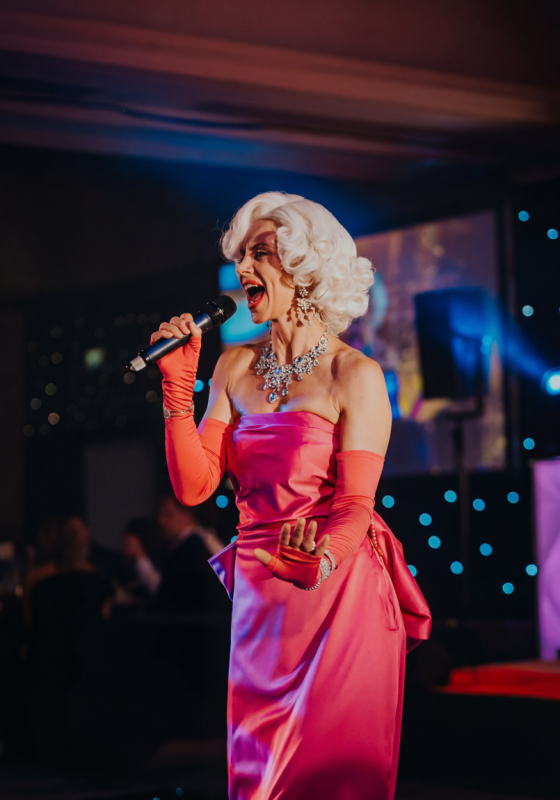 The performer dressed in Marilyn's iconic pin dress mid song holding a microphone