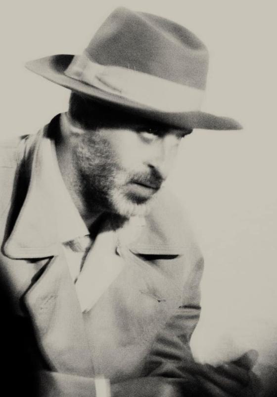 A blurry, black and white image of a person staring intensely to the side.
