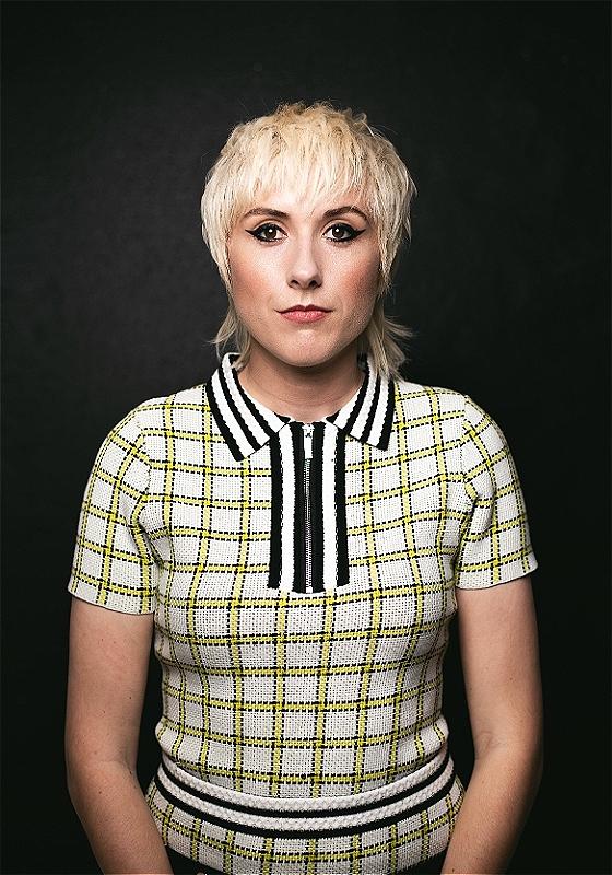 Maisie Adam looking directly into the camera against a black background
