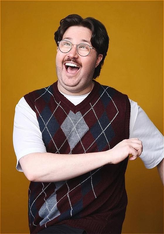 Al Nash looks jolly in front of a yellow backdrop.