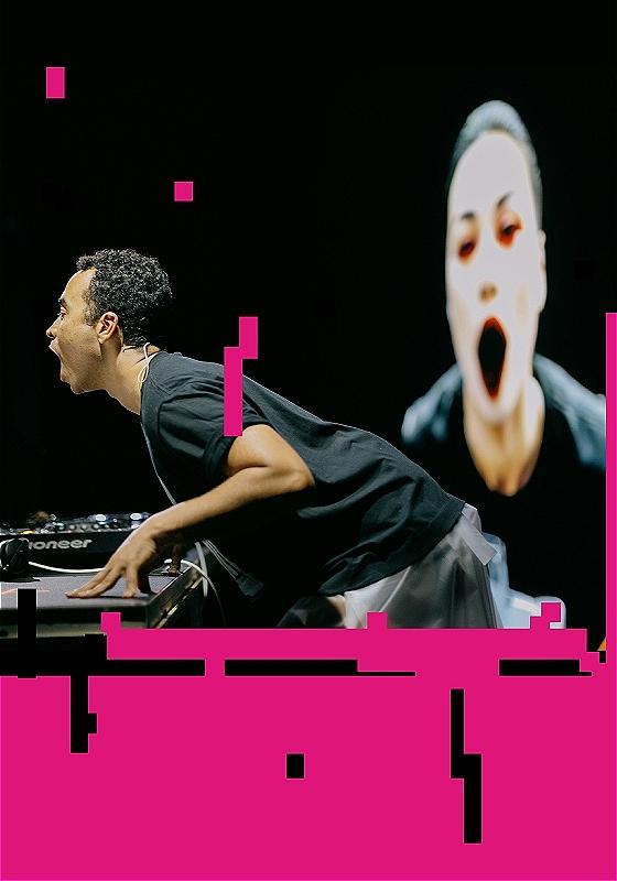 a picture of someone learning over a tech desk, the image is pixelated and pink pixels cover a lot of the image.