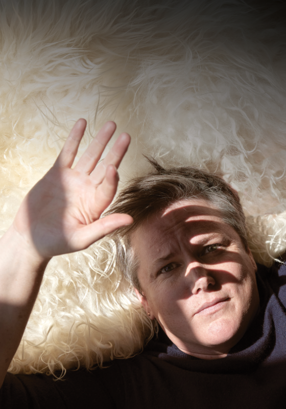 Hannah lying on a white rug, shielding their face from the sun.