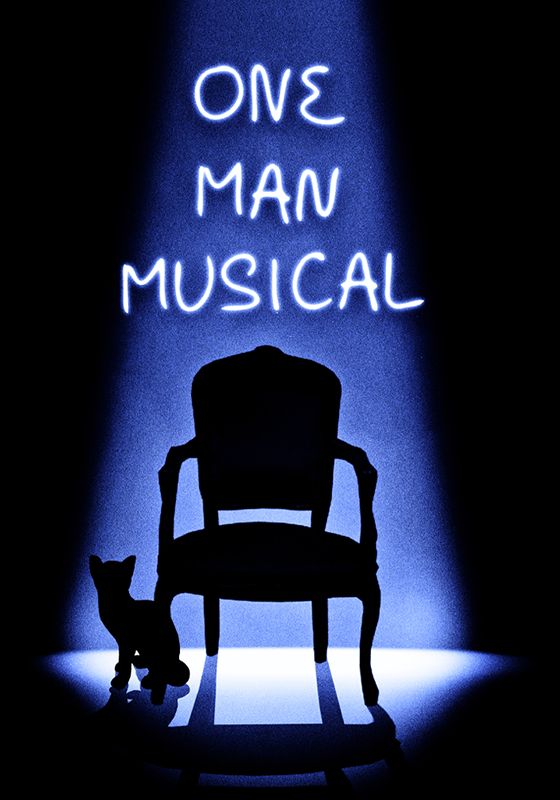 An empty chair is lit by a single spotlight. The outline of a cat can be seen at the spotlight's edge. Above the chair the show's title, One Man Musical, is written.