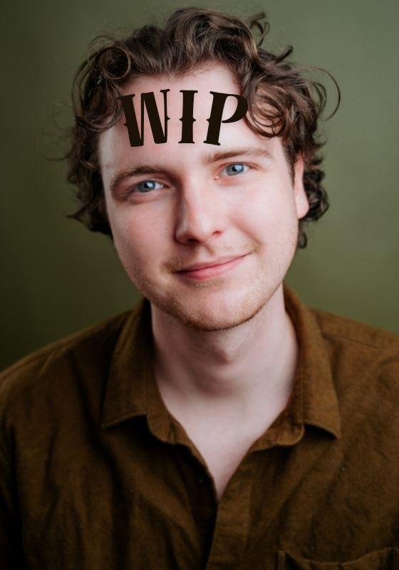 A headshot of the performer with the WIP printed across their forehead.