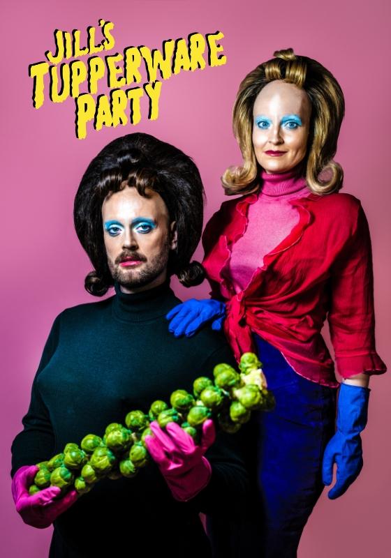 An 80s style couples image. One person is seated in front of the other person, who stands behind them with a hand on their shoulder. They are both wearing big wigs with curled fringes, rubber gloves, and blue eyeshadow.