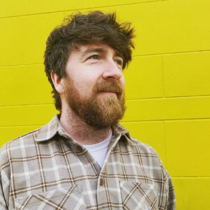 Man stands in front of yellow wall