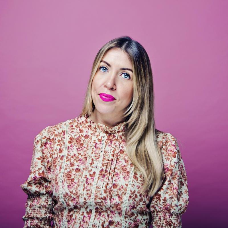 Louise in a floral dress against a pink background