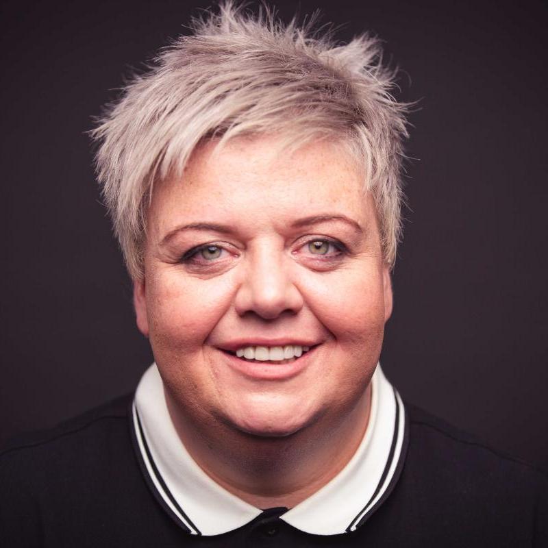 Colour headshot of Susie McCabe who wears a black polo shirt with a white collar.