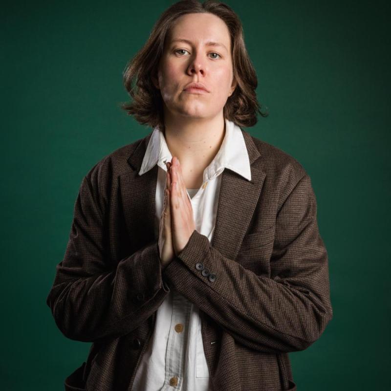 Chloe Petts looking at the camera with her hands held in prayer