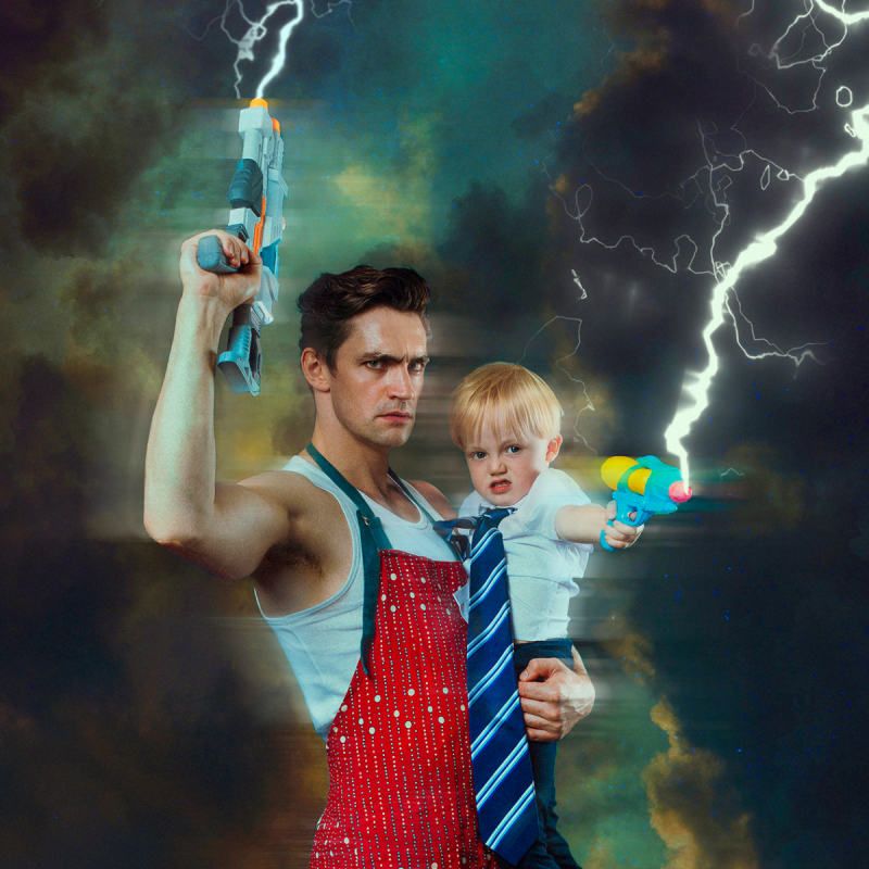 A man holds a baby. They're both in front of a thunderous background holding water pistols shooting out electric energy.
