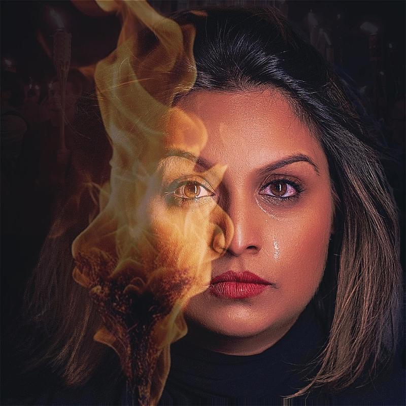 #A close up of a woman's face. On one side, a fire blares across her face using the magic of editing. On the other, a single tear.