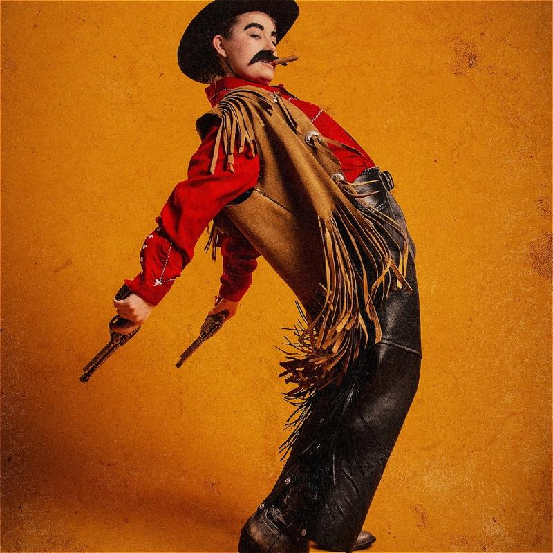 A mustachioed cowboy thrusts their pelvis forward and their gun-wielding hands fly back from the momentum. A cigar hangs from their mouth and tassels hang from their jacket.