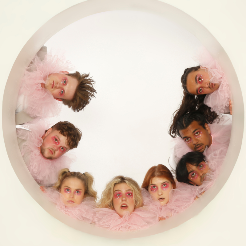 People in pink ruffs look out from a circular white window.