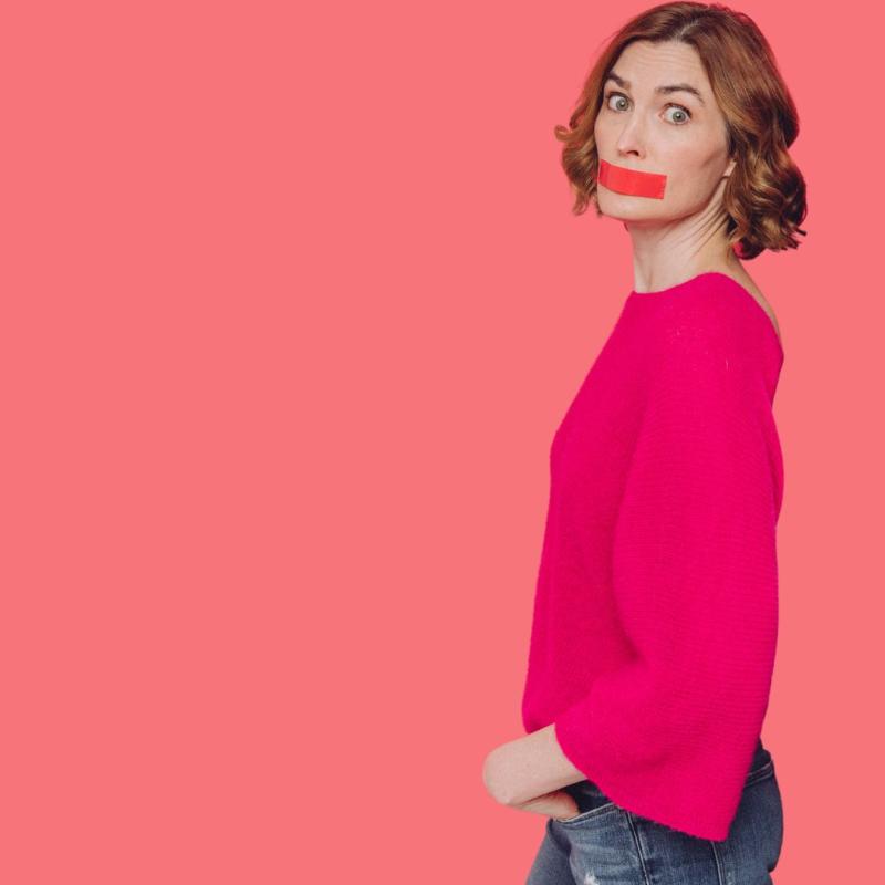 Picture of a person in a pink jumper with red tape across their face.