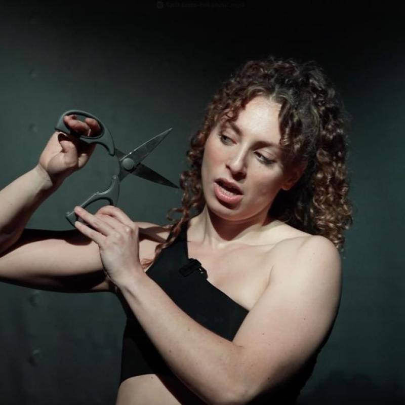 Woman with scissors close to her face.