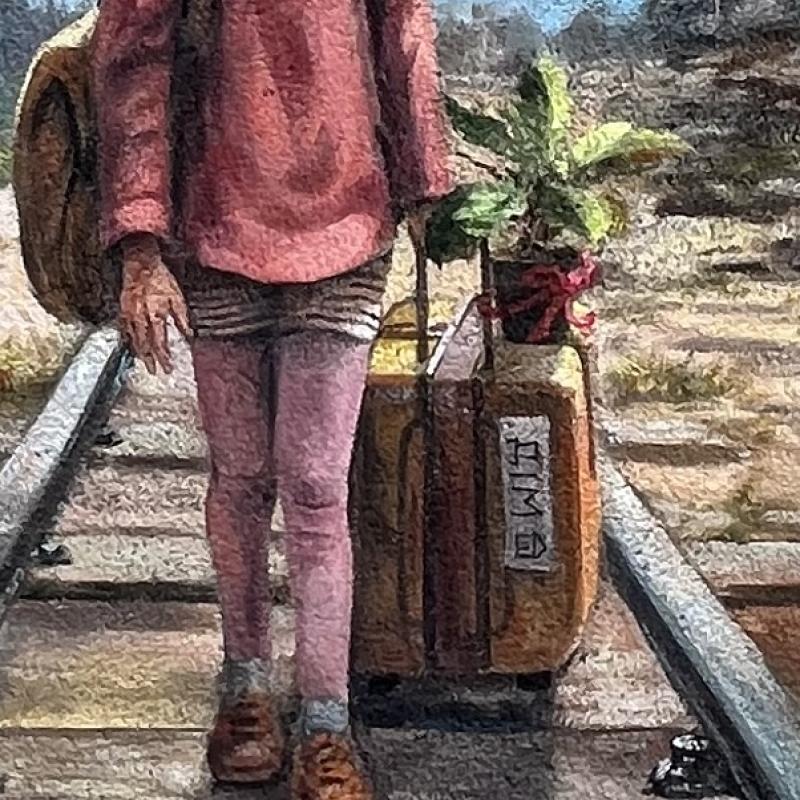 A close up of a young girl walking along a train track with her suitcase