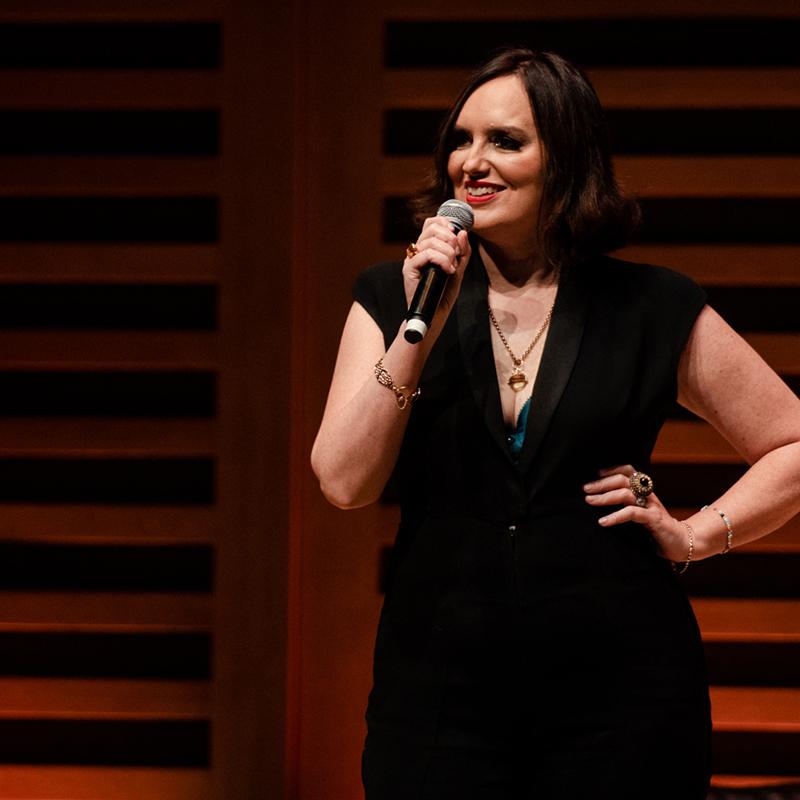 Deborah standing on stage with a mic