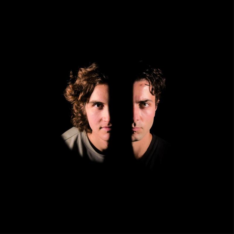 Half the faces of two men. The rest of the photo is obscured in darkness.