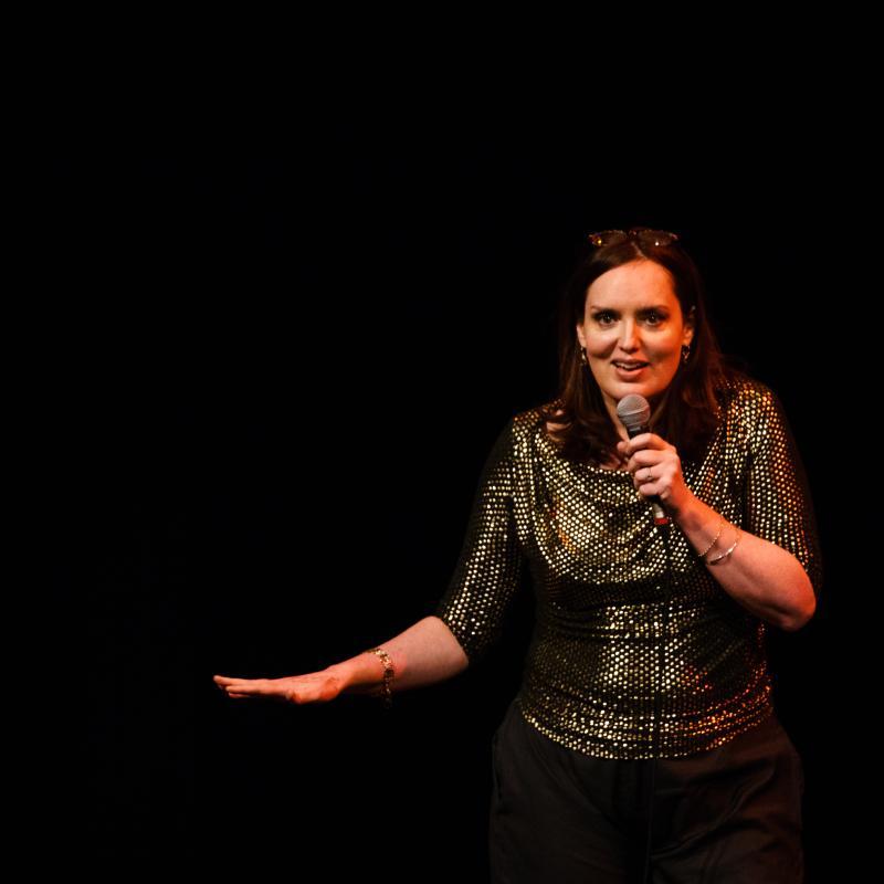 Deborah standing on stage with a mic