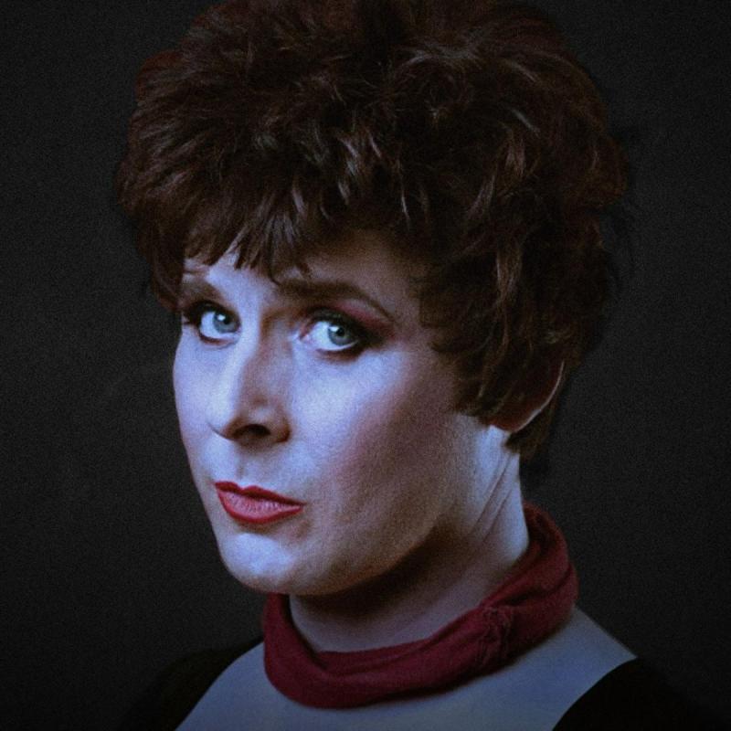 Colin Hoult as Anna Mann staring pensively at the camera with a gloomy filter