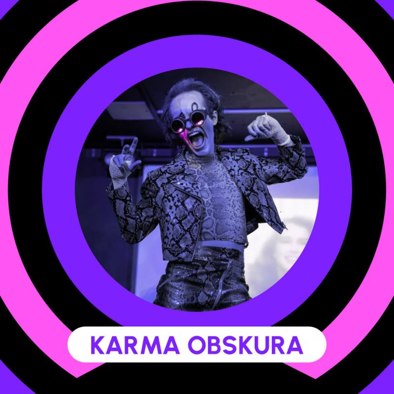 Poster showcasing Karma Obskura. Smiling expressions with both hands up to the side of their head. Costume in snake skin, jacket, shirt and trousers. Wearing steampunk sunglasses.