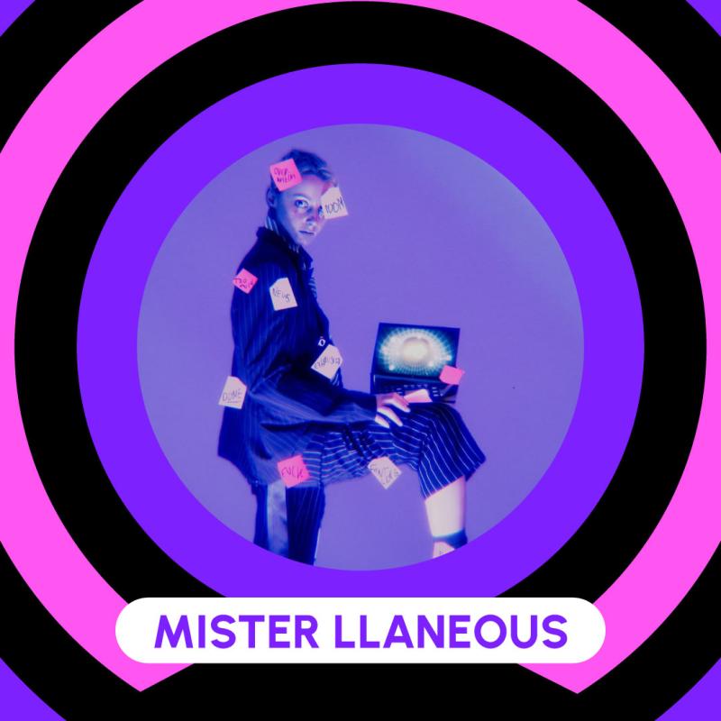 Poster showcasing Mister Llaneous. Blond drag king with short hair. He is wearing a suit with thin white stripes. One foot on a chair with a computer balancing on his knee. Post-it notes are scattered all over his body.