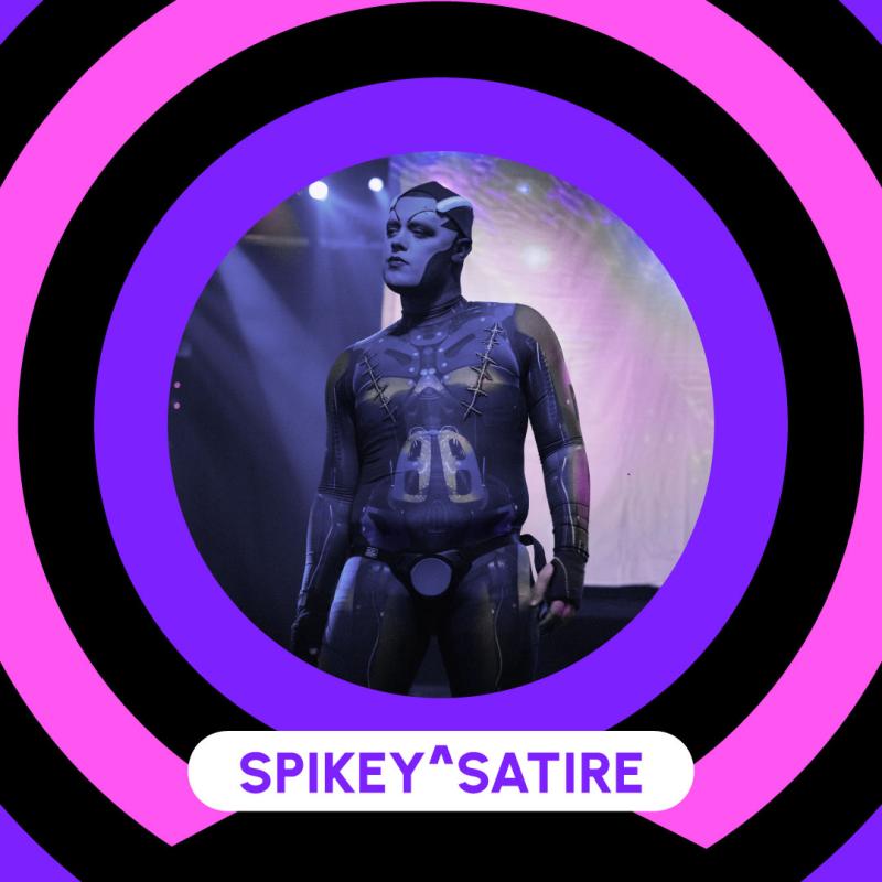 Poster showcasing Spikey^Satire. Stand in a daring position with their arm along their body. They wear a second skin with a electronic pattern. They have electronic components attached to their bold head.