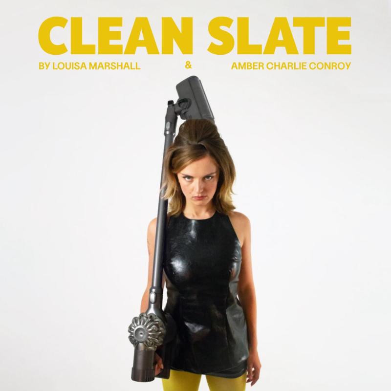 woman staring down the camera holding a hoover