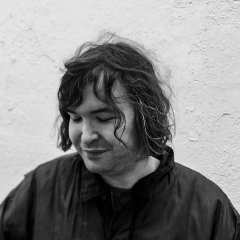 Black and white headshot of Johnny White looking down.