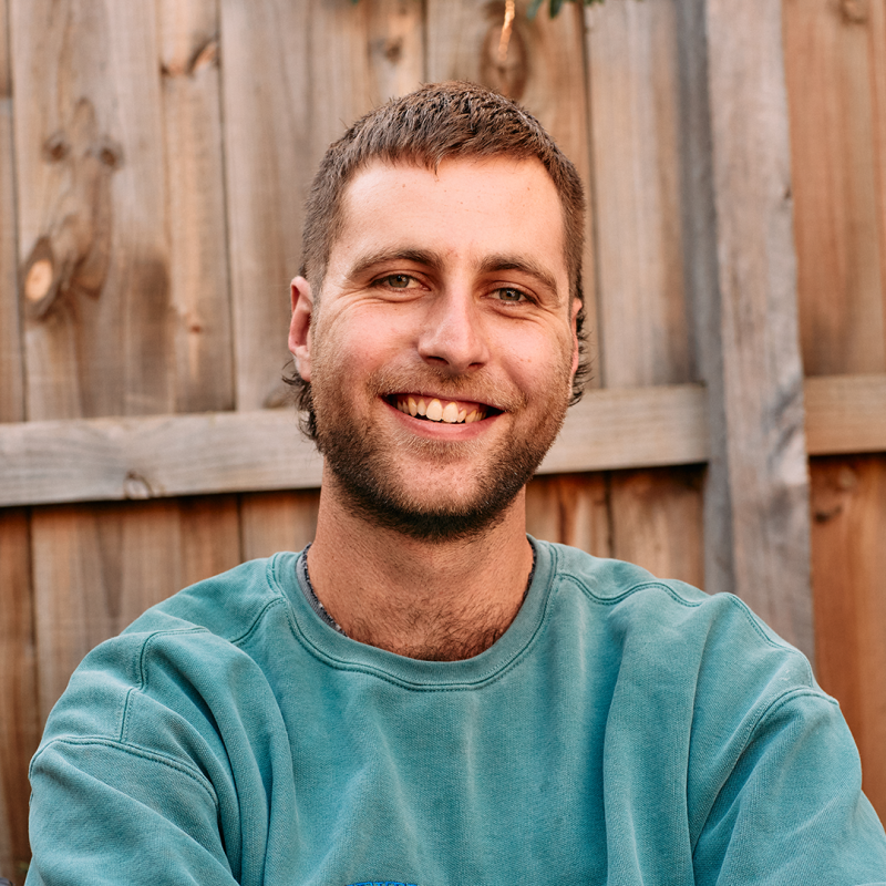 Picture of Lewis smiling in a blue sweatshirt.