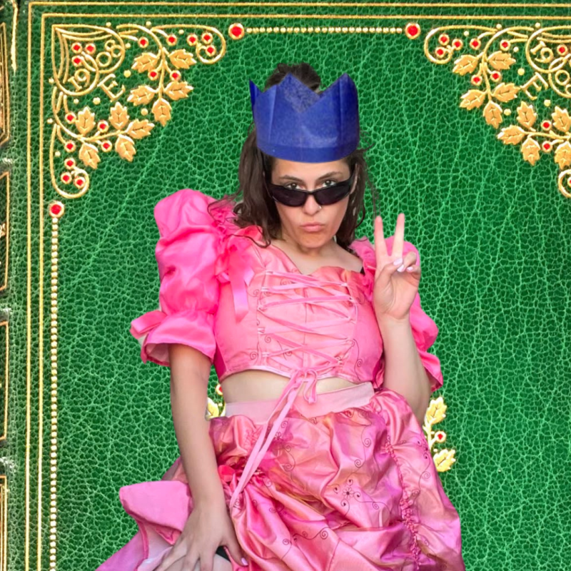 Clementine in a paper crown and sunglasses pouting at the camera