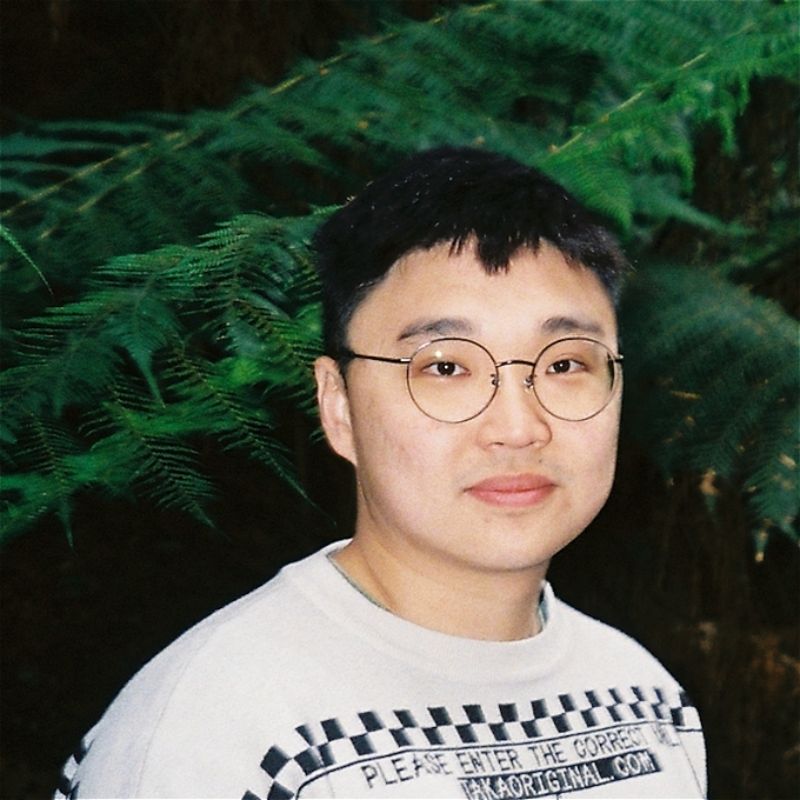 Photo of Jin Hao Li stood in frotn of a large fern.
