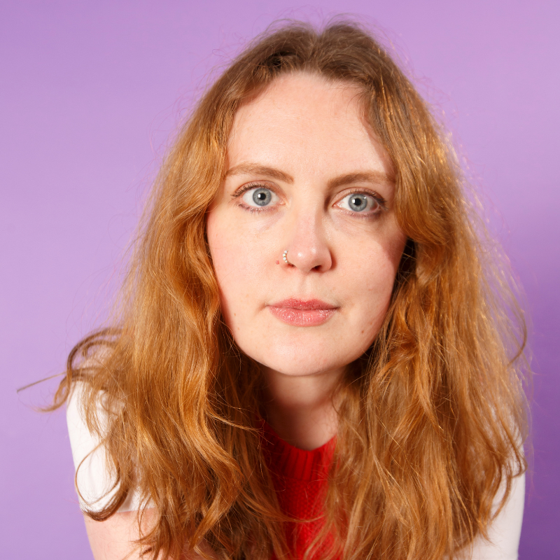 A closeup of Emmeline against a lilac background.