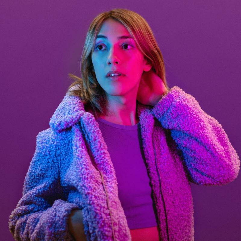 A photograph of the performer wearing a fluffy coat and crop top.