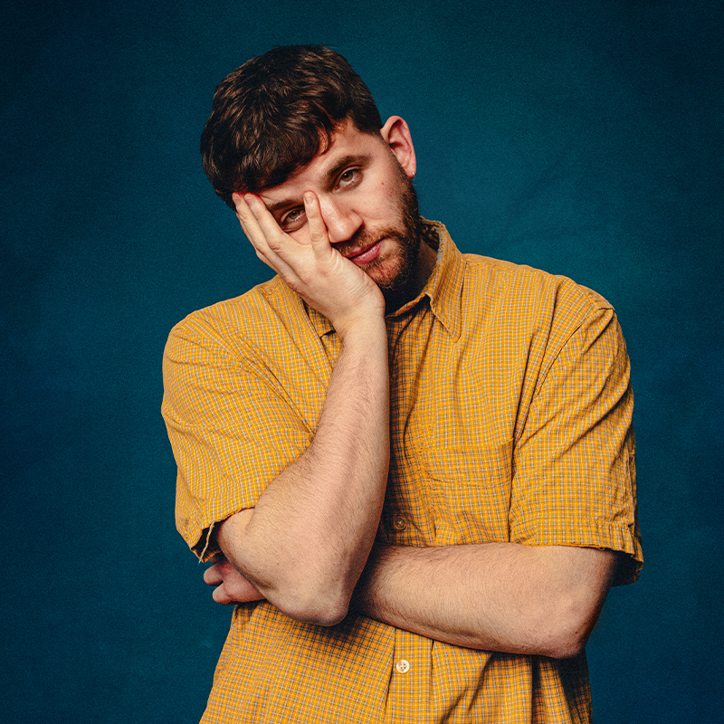 Photo of Rory with arms folded, one hand holding up his face.