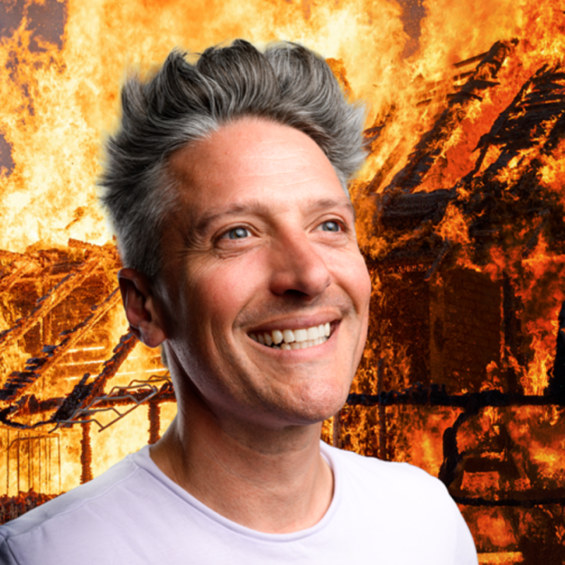 Stu grinning as a fire blazes in the background.