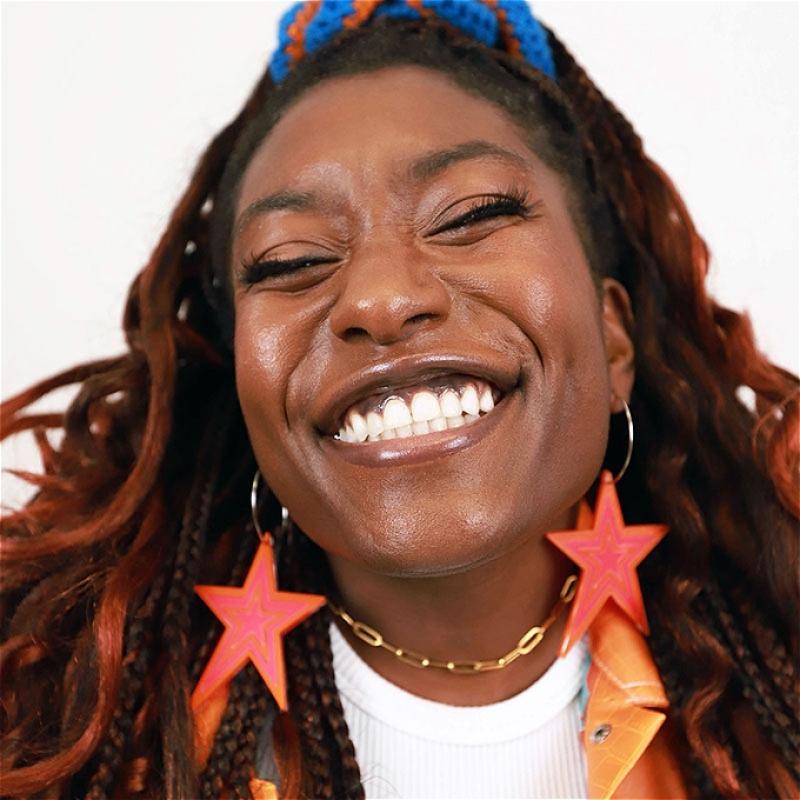 Photo of Sophie with a big smile and eyes partially closed in delight.