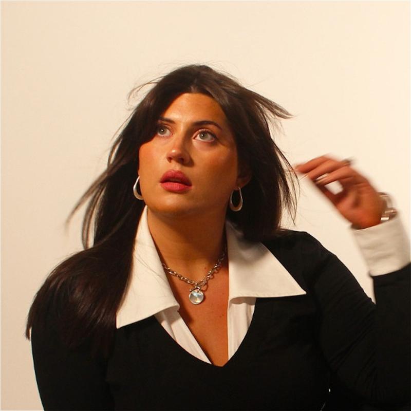 Headshot of Maia posing with windswept hair.