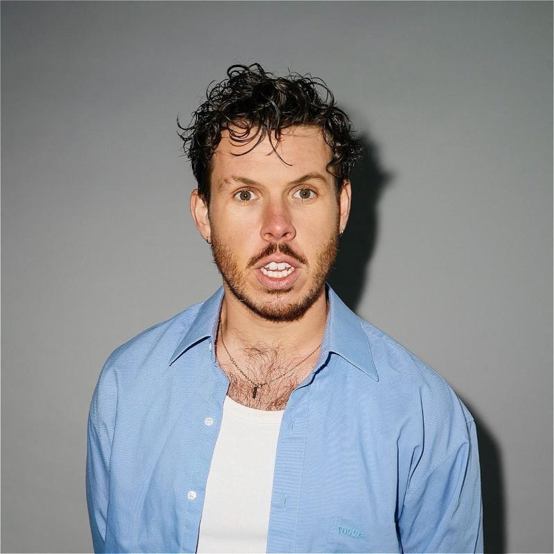 Photo of performer wearing a white t shirt and blue shirt.