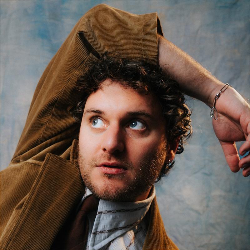 Closeup on Jonathan , who has his arm twisted over his head in a painful looking angle.