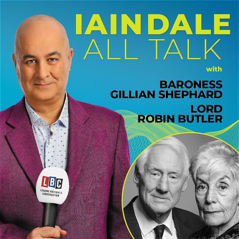 Host Iain Dale stares straight ahead with an LBC microphone wearing a purple blazer before a blue background. A black and white photo of the guests in the bottom right corner.