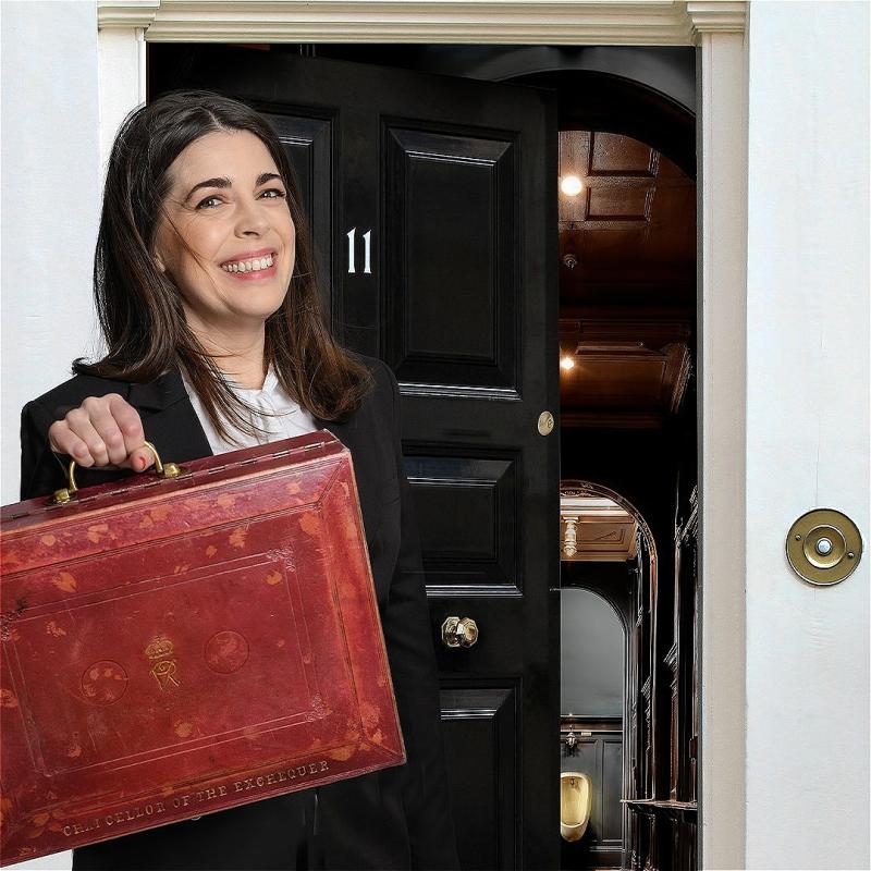 A woman wearing a black blazer holds a red suitcase in front of a black door marked 11 that is slightly ajar, leading into a dark hallway with a shining urinal at the end.