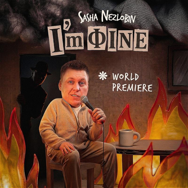 Sasha sits with a microphone at a table. The fire around them is ablaze. A doorway behind him shows a dark figure peering into the room. 