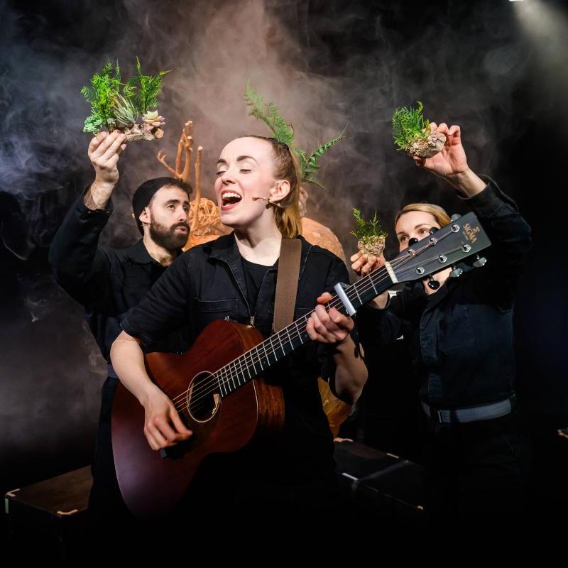 Musician singing with guitar, with planets flying around.