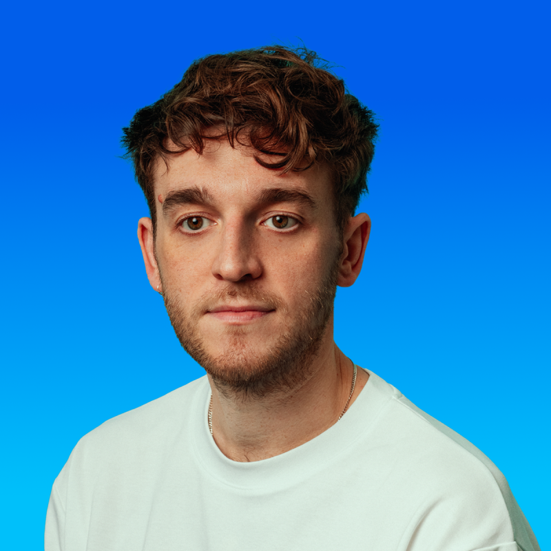 Dave staring ahead wearing a white t-shirt against a blue background.