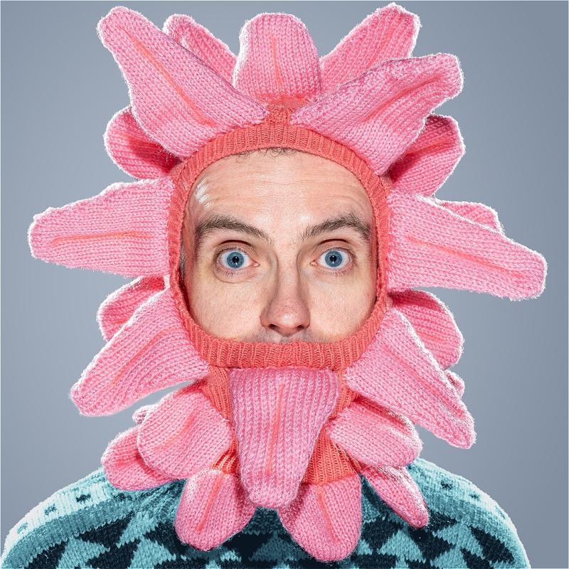 A man wears a knitted balaclava of tongues