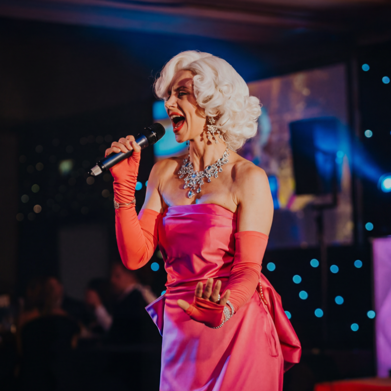 The performer dressed in Marilyn's iconic pin dress mid song holding a microphone