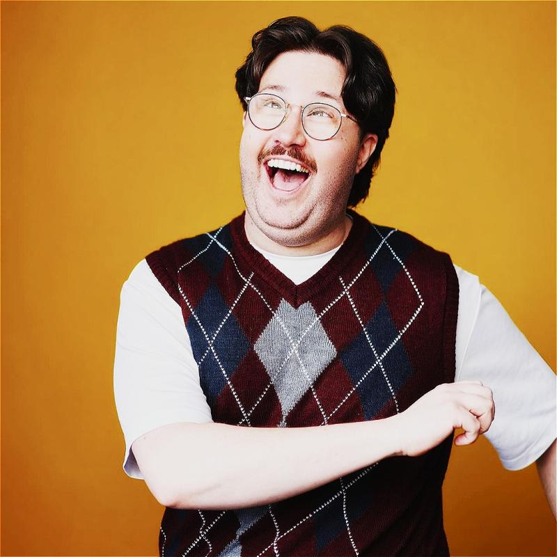 Al Nash looks jolly in front of a yellow backdrop.